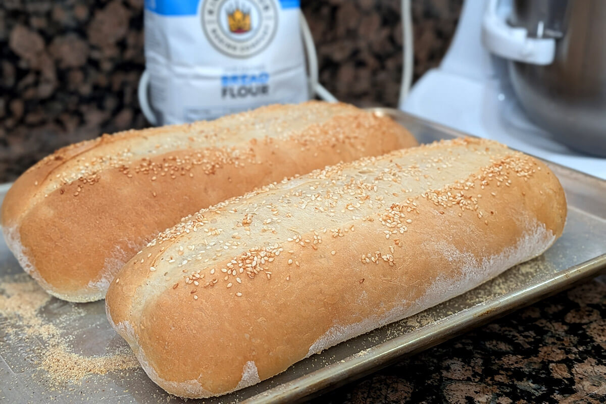 two loaves of homemade italian bread on a baking sheet