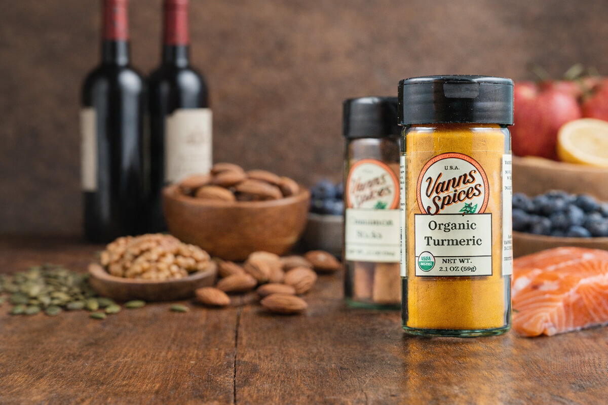a bottle of organic turmeric along with salmon, nuts, red wine, seeds, and blueberries all ingredients of the MIND Diet