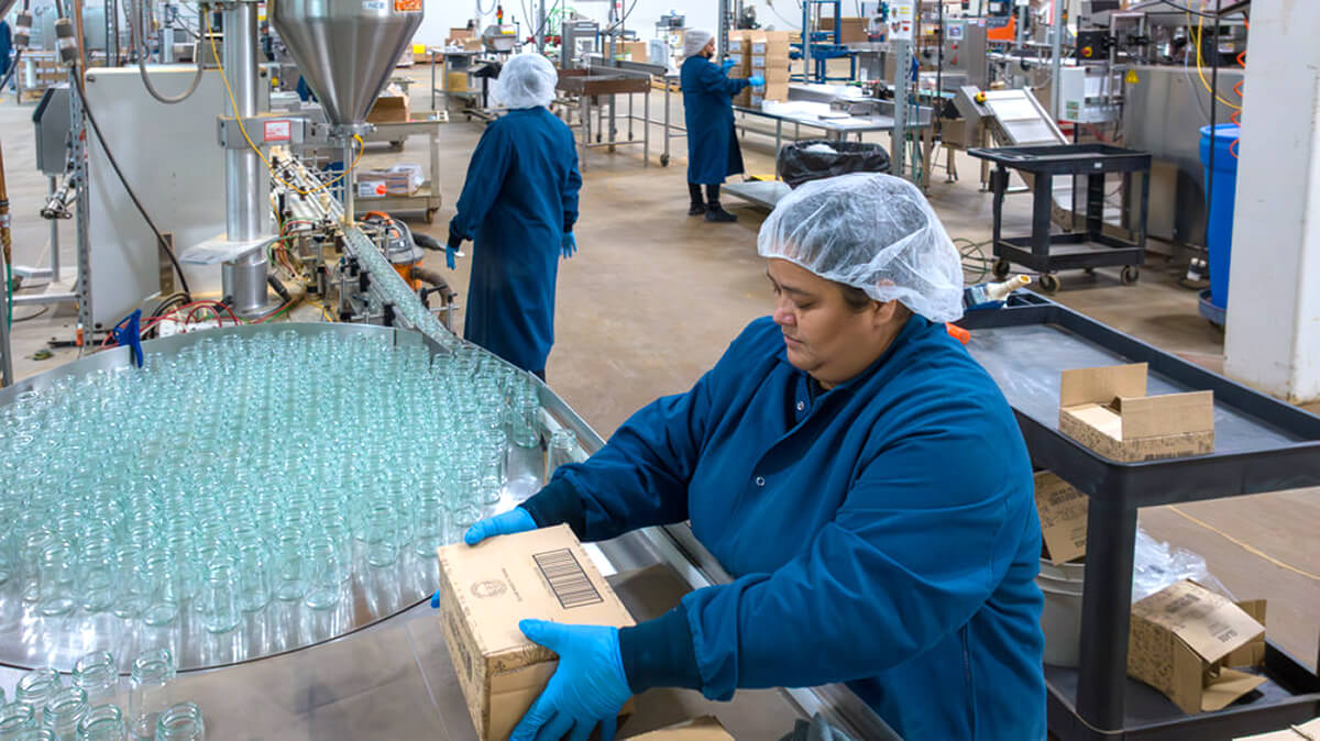 vanns spices employee preparing glass bottles for spice filling