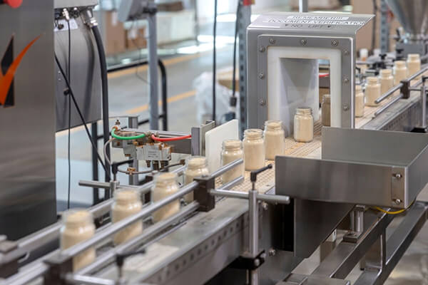 bottles of seasoning on a production line at vanns spices